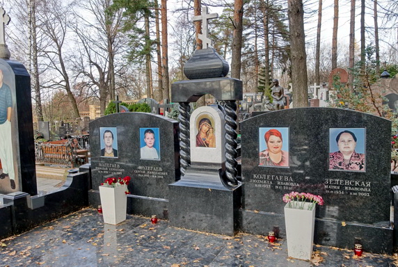 Широкий памятник из чёрного гранита на четырёх покойных